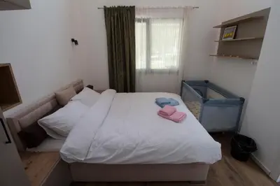 a bedroom with a bed with two pink slippers on it at Apartmani 