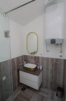 a bathroom with a sink and a mirror at Apartmani 