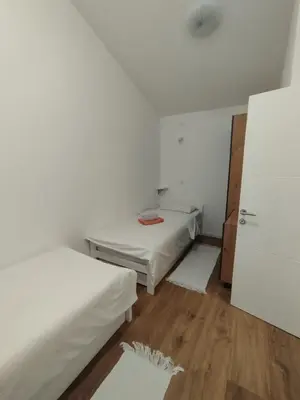 a room with two beds and a door in it at Apartmani 