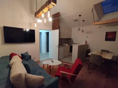 a living room with a blue couch and red chairs at Apartmani 