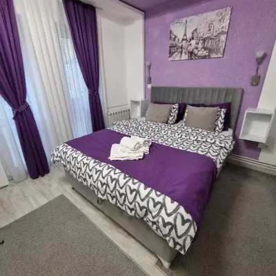 a bedroom with purple walls and a bed with purple sheets at Studio Sestica vila Lenka2 in Vrnjačka Banja