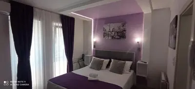 a bedroom with a bed with purple walls and a window at Studio Sestica vila Lenka2 in Vrnjačka Banja