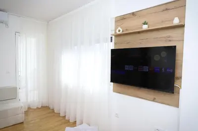 a living room with a flat screen tv on a wall at Apartman Aleksandra Vrnjacka Banja in Vrnjci