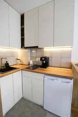 a white kitchen with white cabinets and a sink at Apartman Aleksandra Vrnjacka Banja in Vrnjci