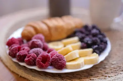 a plate of fruit and pastries on a table at Apartman Jež in Kuršumlija