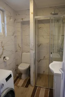 a bathroom with a toilet and a shower and a sink at Apartman Jež in Kuršumlija