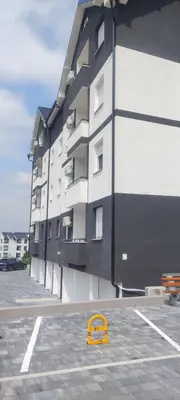 a yellow object in a parking lot next to a building at Apartman Ivana in Soko Banja