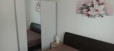 a bedroom with a couch and a picture of flowers on the wall at Apartman Ivana in Soko Banja