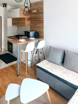 a living room with a couch and a kitchen at Apartman Lena in Vrnjačka Banja