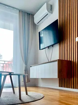 a living room with a table and a flat screen tv at Apartman Lena in Vrnjačka Banja