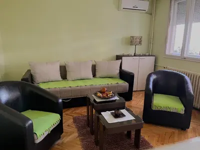 a living room with two chairs and a couch at Cozy place for a perfect trip next to Delta Planet in Niš