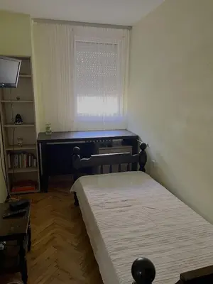 a small bedroom with a bed and a window at Cozy place for a perfect trip next to Delta Planet in Niš