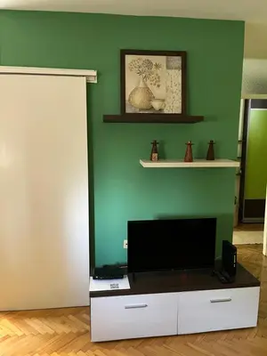 a living room with a flat screen tv on a white cabinet at Cozy place for a perfect trip next to Delta Planet in Niš