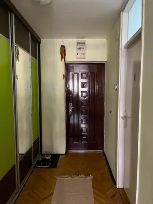 a hallway with a wooden door in a room at Cozy place for a perfect trip next to Delta Planet in Niš