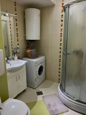 a bathroom with a washing machine and a washer at Cozy place for a perfect trip next to Delta Planet in Niš