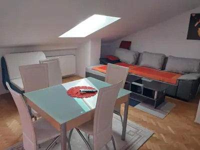 a living room with a table and chairs and a couch at Apartman u Nisu in Niš