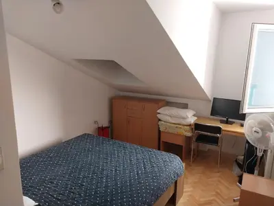 a bedroom with a bed and a desk with a computer at Apartman u Nisu in Niš