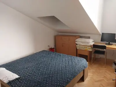a bedroom with a bed and a desk with a computer at Apartman u Nisu in Niš