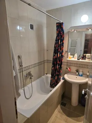 a bathroom with a bath tub and a sink at Apartman u Nisu in Niš