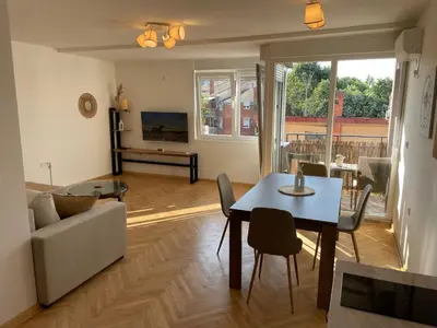 a living room with a table and a couch at La Familia Apartmani in Vrnjačka Banja
