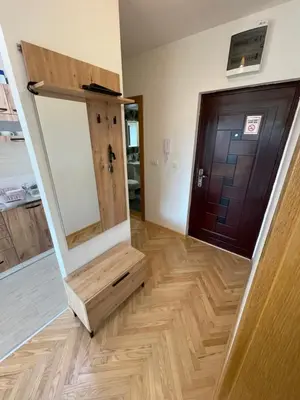 a hallway with a mirror and a wooden door at La Familia Apartmani in Vrnjačka Banja