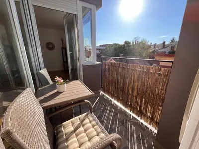 a balcony with a table and chairs on a balcony at La Familia Apartmani in Vrnjačka Banja