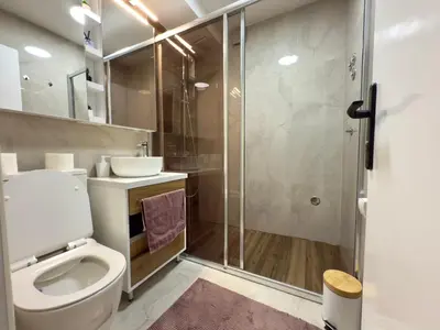 a bathroom with a toilet and a glass shower at Maribelle Apartments in Kruševac
