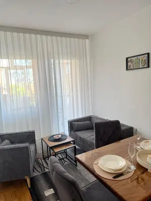 a living room with a table and a couch at Maribelle Apartments in Kruševac