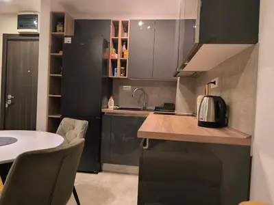 a kitchen with black cabinets and a table with chairs at COMODO 