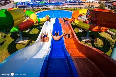a group of people riding a water slide at a water park at COMODO 
