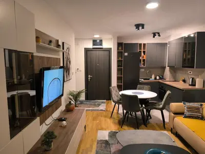 a living room with a couch and a table with a tv at COMODO 