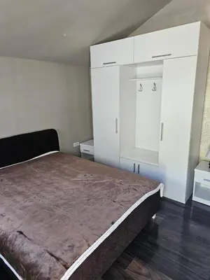 a bedroom with a large bed and white cabinets at Prenociste Vranjska banja in Vranjska Banja