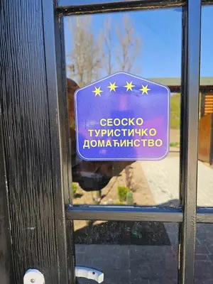 a window with a sign on the door of a building at Prenociste Vranjska banja in Vranjska Banja