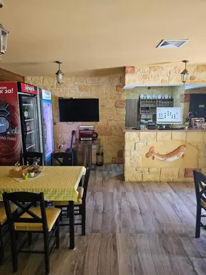 a restaurant with a table and chairs and a television at Prenociste Vranjska banja in Vranjska Banja