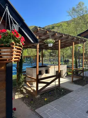 a wooden pergola with a bench and flowers in it at Prenociste Vranjska banja in Vranjska Banja