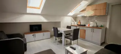 a small living room with a table and a kitchen at Studio Dumitrašković in Soko Banja
