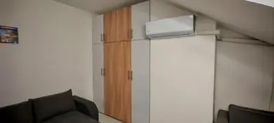 a room with a tv and a couch and a cabinet at Studio Dumitrašković in Soko Banja