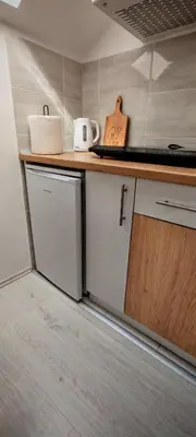a kitchen with white cabinets and a counter top at Studio Dumitrašković in Soko Banja