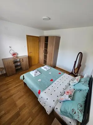 a bedroom with a twin bed and wooden floors at Apartman Nina in Soko Banja