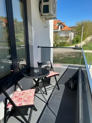 a balcony with a table and two chairs and a tv at Apartman Nina in Soko Banja