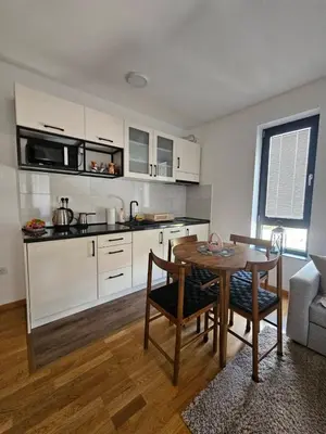 a living room with a table and a kitchen at Apartman Nina in Soko Banja