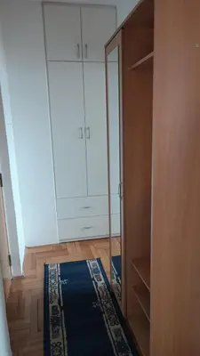 a white closet with a mirror and a blue rug at Nisava rest in Niš