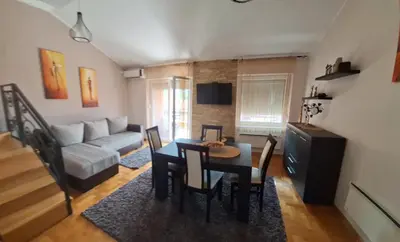 a living room with a table and a couch at Royal Lux in Soko Banja