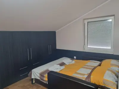 a bedroom with a bed and a window and cabinets at Royal Lux in Soko Banja