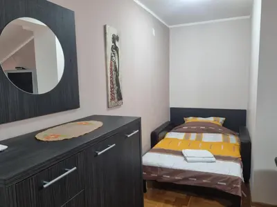 a bedroom with a bed and a dresser with a mirror at Royal Lux in Soko Banja