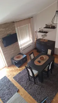 a living room with a table and chairs and a television at Royal Lux in Soko Banja