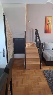 a living room with a staircase with a couch at Royal Lux in Soko Banja