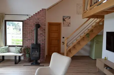 a living room with a wood stove and a staircase at Montana Goc in Goč