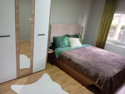 a bedroom with a bed and a mirror at Zen apartman in Zaječar