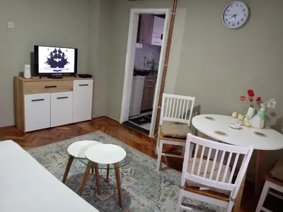 a living room with a table and chairs and a television at Zen apartman in Zaječar